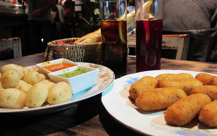 potatoes, croquettes and drinks on a bar